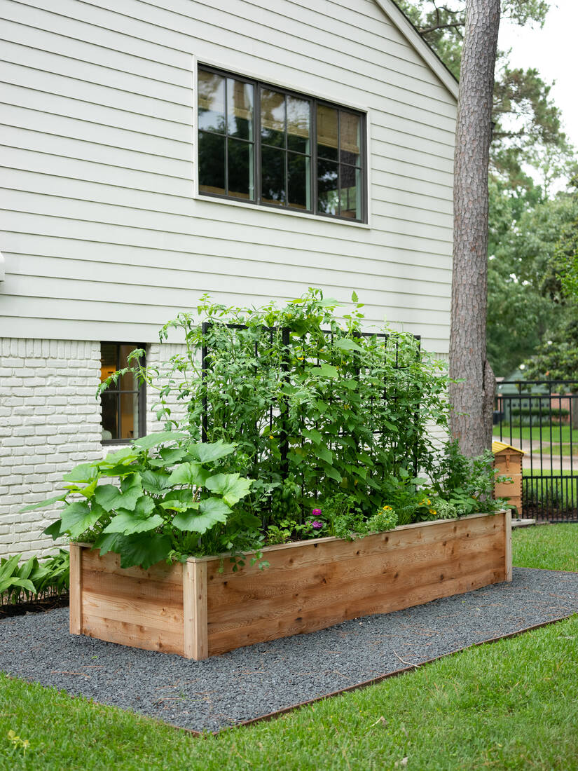 The Gwen Garden Package: a long cedar raised bed with a black grid trellis against a white house